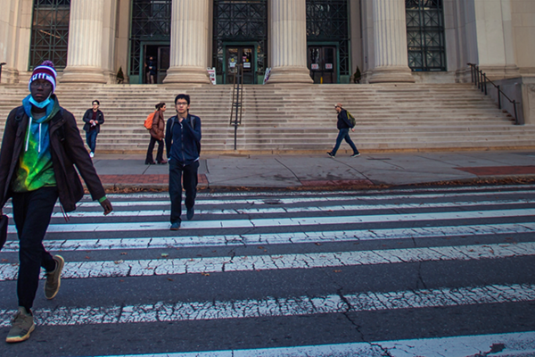 several people crossing the crosswalk in front of MIT's Building 10 at 77 Massachusetts Avenue in Cambridge, MA